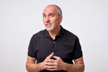 Ne yaptığını söyle, tekrar kavramı. Siyah tişörtlü rahatsız şüpheli çekici olgun adam portresi
