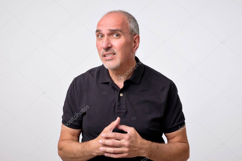 What did you say, repeat concept. Portrait of annoyed questioned attractive mature man in black shirt