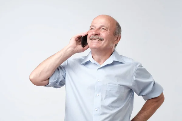 Portrait of happy european senior man talking on phone and smiling — Stock Photo, Image