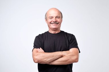 Büyüleyici üst düzey yakışıklı rahat kıyafetler geçti ve gülümseyen silah tutmak