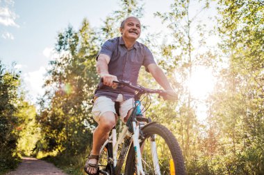 Neşeli komuta sizde güzel güneşli bir günde bir parkta Bisiklete binmek. Aktif yaşam kıdemli yaş. Spor tatil kavramı