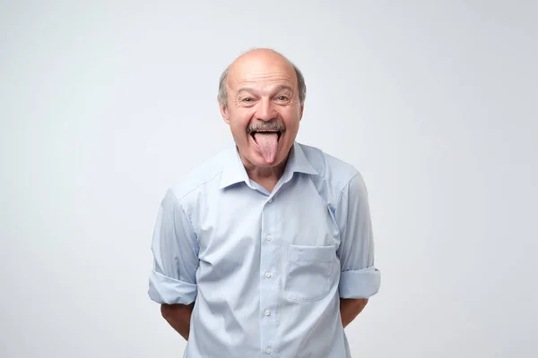 Hombre hispano maduro mostrando lengua. Divertida mueca . —  Fotos de Stock