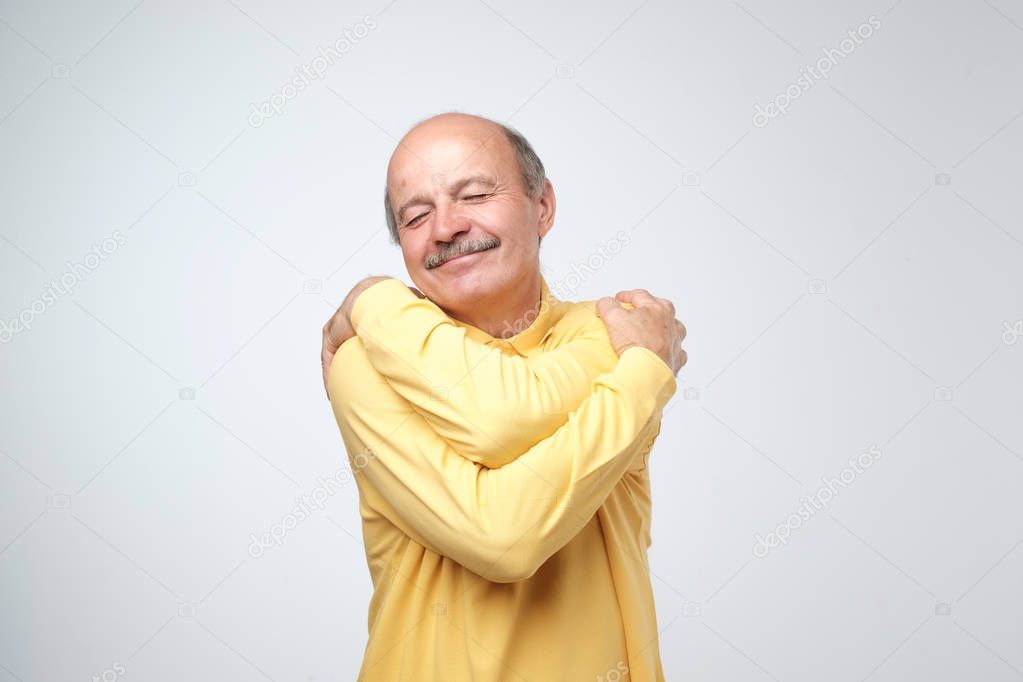 Closeup portrait confident smiling man hugging himself. I am the best concept. Soft clothes after washing