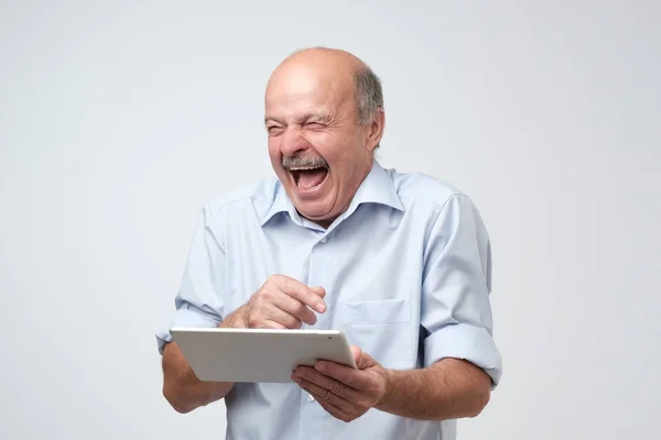 Cheerful Mature European Man Laughing Holding Tablet White Background — Stock Photo, Image