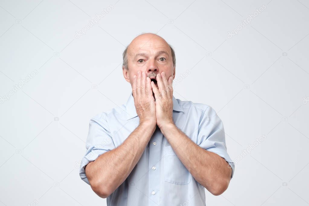 Shocked caucasian man face. He is closing his face with hands. It can not be true concept