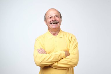 Yakışıklı komuta sizde rahat kıyafetler silah tutmak içinde büyüleyici geçti ve üzerinde beyaz arka plan ayakta gülüyor izole.