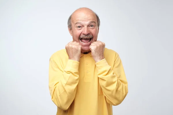 Szczęśliwy Człowiek Starszy Żółty Tshirt Świętować Jego Sukces Szarym Tle — Zdjęcie stockowe