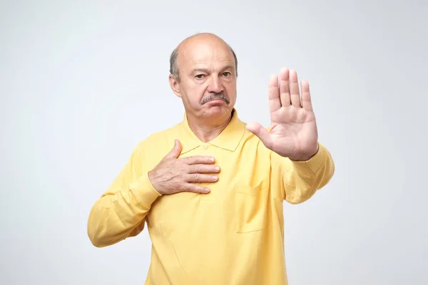 成熟的人在 Yelloe T恤显示标志停止与手 拒绝做某事 负性面部情绪 — 图库照片