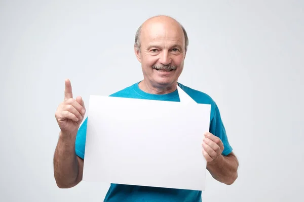 Mogen Skallig Man Blå Tshirt Håller Tomt Pappersark Leende Isolerad — Stockfoto