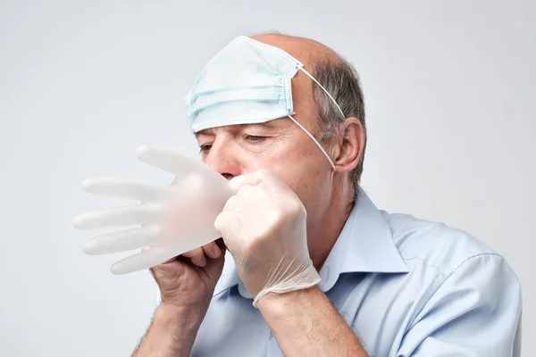 Mature Bald Doctor Wtih Mask Forehead Blowing Medical Glove — Stock Photo, Image