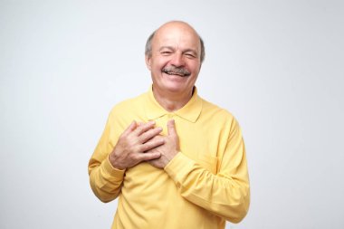 Neşeli adam gülümsüyor ne mutlu ki, göğüs ellerinde tutar. Memnun Erkek kadından iltifat almak memnun.