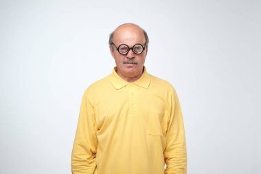 Olgun adam komik gözlük kameraya bakıyor. O üzgün ve memnun.