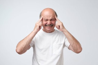 Headshot beyaz t-shirt beyaz adamın parmak üzerinde tapınak tutar, kötü belleğe sahip, konsantre ve kaza ayrıntılarını hatırlıyor çalışır. Çok çalışan adam baş ağrısı vardır, yorgun hissediyor