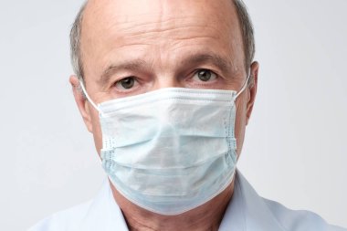 özel doktor maskeli kötü adam portresi. Ciddi bakıyor. Tıbbi sınav kötü sonuçları. Olgun deneyimli doktor. Tıp, sağlık ve hastanede acil