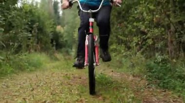 Mavi t-shirt yaz tatilini ağaçlar arasında açık bir bisiklet sürme keyfi kıdemli beyaz erkek.