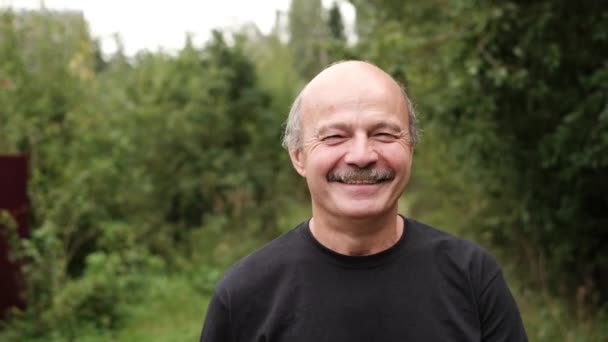 Glücklicher älterer Mann aus Kaukasien, der draußen im Park an Bäumen spaziert. — Stockvideo