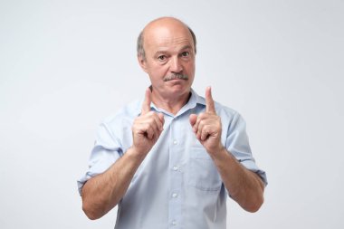 İşaret parmağı ile kötü memnun, sallayarak kıdemli Avrupa erkek portresi sinirli davranışlar ve öğretim çocuk iyi terbiye ya da davranış