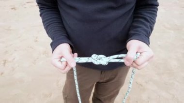 Adam nasıl corrext resif düğüm ve sonra Büyükanne düğüm yapmak gösterilen
