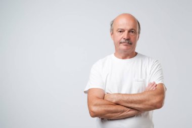 Yakışıklı komuta sizde rahat kıyafetler silah tutmak içinde büyüleyici geçti ve üzerinde beyaz arka plan ayakta gülümseyen izole. Olumlu yüz duygu