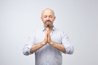 Yoga ve meditasyon sırasında iş günü ofisinde. Yakışıklı kel adam gözlerini tutmak kıl ile meditasyon sırasında rahat, sakin, huzurlu tutuşup mudra işareti duygu kapalı.