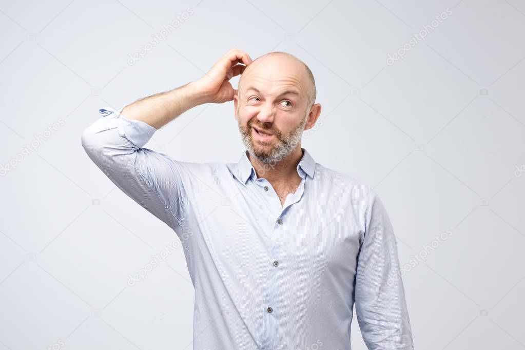Mature european bearded young male dressed in casual white shirt trying to remember where he put the car keys. I have to remember what my wife told me to do. Negative human emotions and feelings