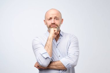 Ne yazık ki kameraya bakacak Avrupa adam. Sakallı yakışıklı olgun yetişkin, iş ve gelecekteki yaşam hakkında düşünme kaybetti. Beyaz stüdyo arka plan üzerinde duran tek başına