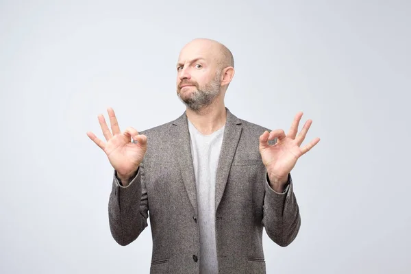 Een Knappe Man Pak Geïsoleerd Een Grijze Achtergrond Weergegeven Teken — Stockfoto