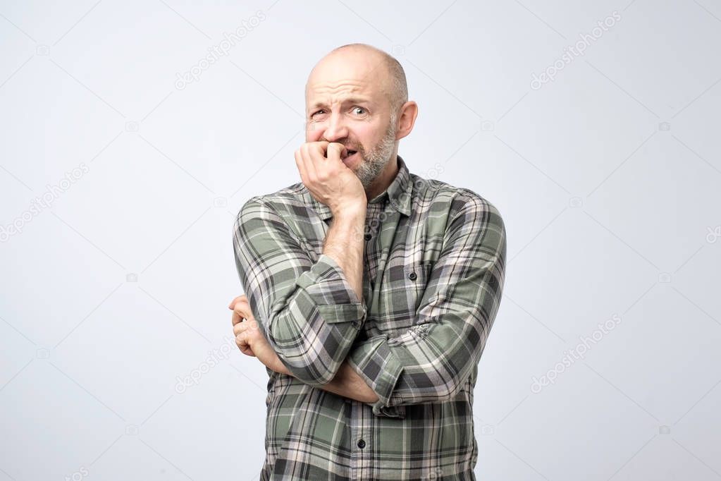 Nervous scared european guy has sorrorful expression, clenches teeth, tries not to cry, finds out about tragic event. Stressed male feeling nervous because of family problems