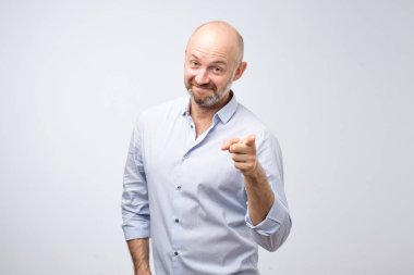 Sen bu işte iyisin demek gibi gri bir arka plan üzerinde izole gösteren gülümseyen memnun adam portresi. İyi kavramı