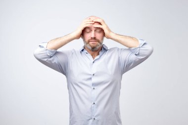 Stüdyo portre üzgün üzgün, depresif, yorgun adam baş ağrısı ve beyaz arka plan üzerinde negatif insan duygu yüz ifadesi izole çok stresli yüz endişeli