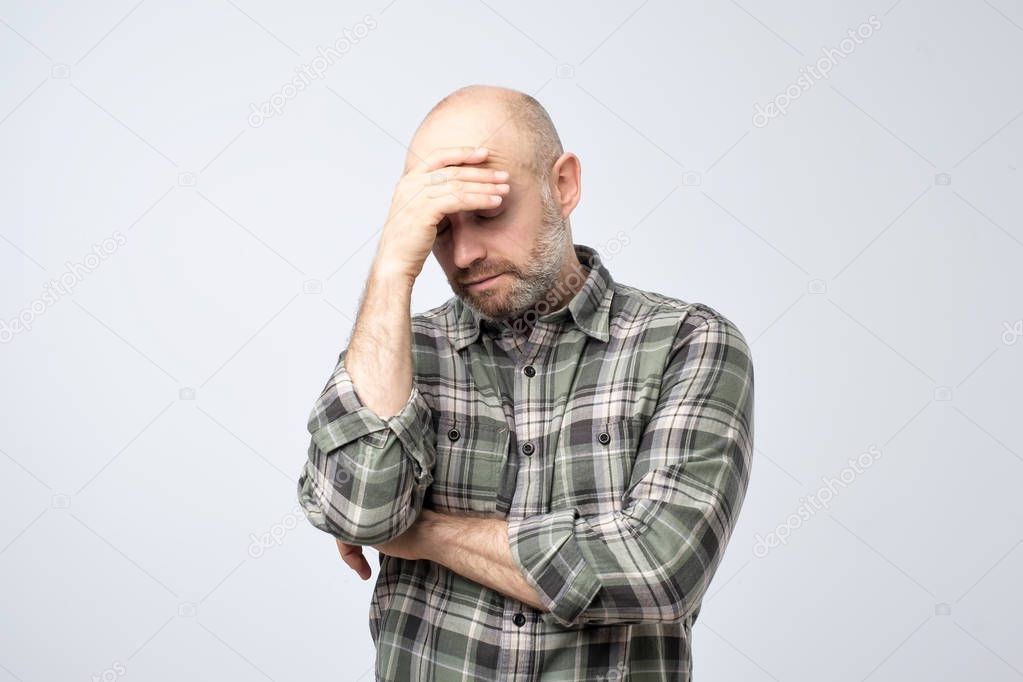Studio portrait of upset worried sad, depressed, tired man with a headache and very stressed face, isolated on white background, Negative human emotion facial expression