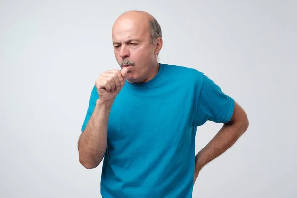 Mature hispanic man in blue t-shirt man coughing being ill. — Stock Photo, Image
