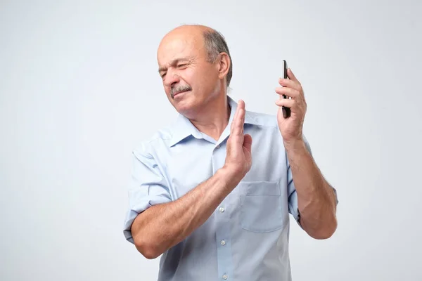 Mature handsome man refusing to speak on the phone over isolated background turning his face from it — Stock Photo, Image