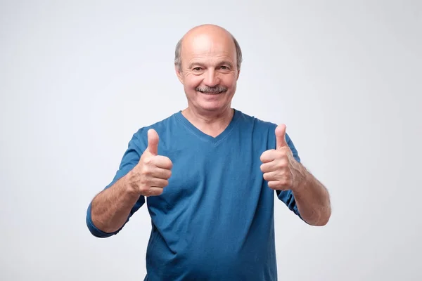 Hombre mayor guapo en camisa azul muestra el pulgar hacia arriba . —  Fotos de Stock