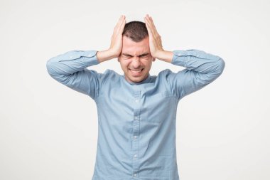 Stresli genç adam fotoğrafı korkunç baş ağrısı, sinirli ve depresif, clenches diş acı içinde olmak hissediyor, ağrısı muzdarip, gözlerini kapatır, kız arkadaşı ile ilişkilerde bir sorun vardır