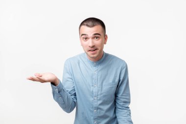 Stüdyo mavi kumaş yakışıklı İspanyol adam portresi, ters bakarak ve omuzlarını orada gösterilen shrugging onun durumla yapabileceği bir şey olduğunu. Yüz ifadeleri.