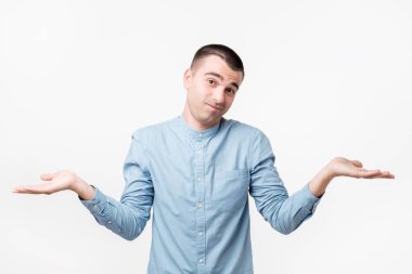 Stüdyo mavi kumaş yakışıklı İspanyol adam portresi, ters bakarak ve omuzlarını orada gösterilen shrugging onun durumla yapabileceği bir şey olduğunu. Yüz ifadeleri.