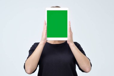 Genç kadın yüzü ile kopya alanı ile ekranın önünde boş bir tablet gidiyor