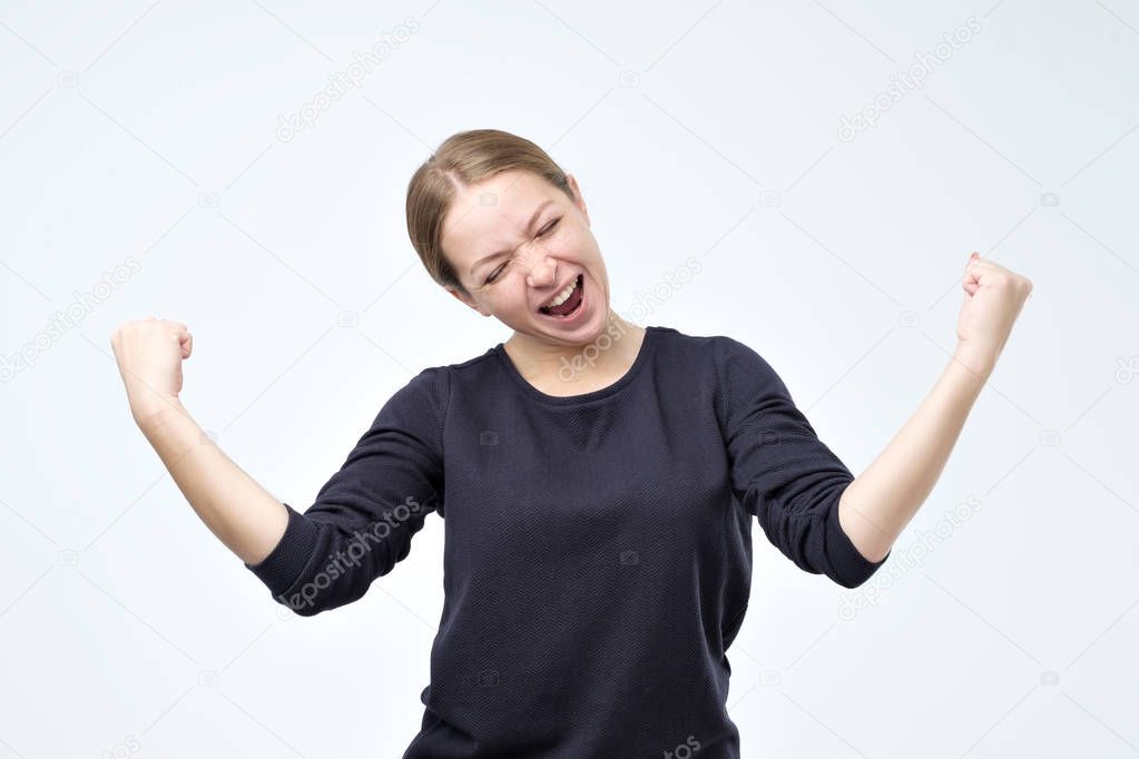 portrait of happy woman celebrating winning in lottery or passing exam