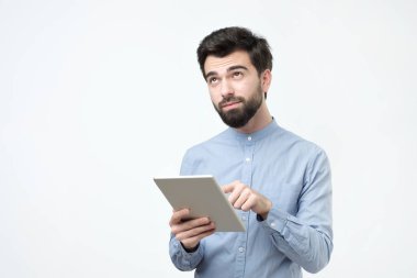 Beyaz arka plan üzerinde tablet kullanan yakışıklı adam. Stüdyo çekimi