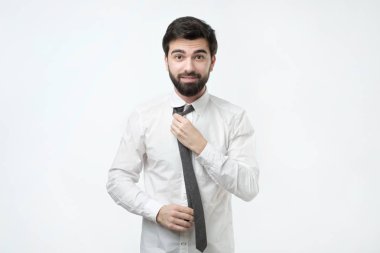 Yakışıklı işadamı hazırlamak beyaz arka plan üzerinde takım elbise için. Adam iş için hazırlanıyor.