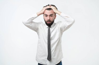 Umutsuz, kafa, şok haber tarafından tutan genç Avrupa adam terör ve şok, kameraya bakarak vurguladı. İşimi çok yorgunum.