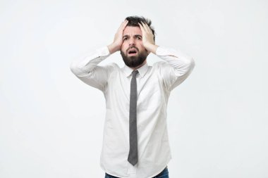 Umutsuz, kafa, şok haber tarafından tutan genç Avrupa adam terör ve şok, kameraya bakarak vurguladı. İşimi çok yorgunum.