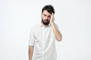 Dağınık saç ve sakal, sürtünme ve yorgun ya da gri arka plan üzerinde duran kalıntı, sahip olan sakallı adam. Karışık ve uykulu adam .