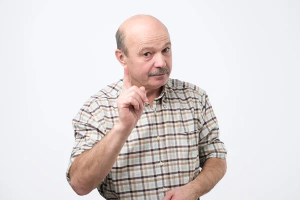 Hombre mayor estricto mostrando los dedos índice hacia arriba, dando consejos — Foto de Stock