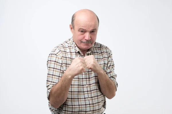 Man standing in boxer pose with raised fists as if defending or fighting — Stock Photo, Image