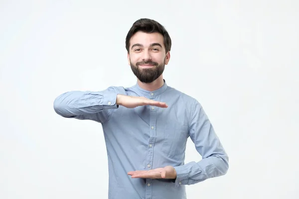 Muž s vousy hospodářství, dvě ruce před sebe a zobrazuje velikost — Stock fotografie