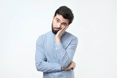 Seyir yorgun ve hasta çok sıkılmış yetişkin adam elini tutarak yanağından, sakallı