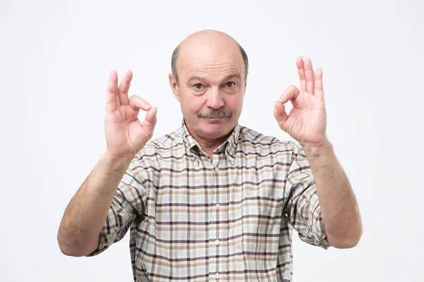 Senior man showing ok sign standing isolated on gray background — Stock Photo, Image