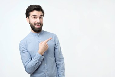 Gülümseyen ve bir kenara eliyle işaret kameraya, mutlu güzel sakallı İspanyol man arıyorum.